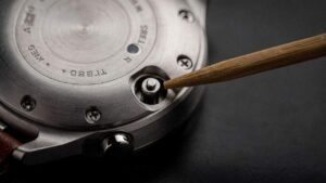 Para que serve o botão escondido atrás do relógio digital?